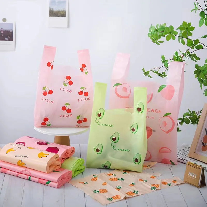 A set of five pink and lime green fruit-print tote bags with handles displayed on a white surface.