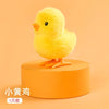 A small yellow wind-up walking chicken toy sitting on an orange circular base.