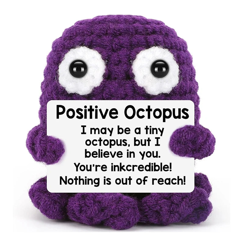 A handmade purple crochet octopus doll with a positive message card.
