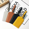 A collection of five classic PU leather luggage tags in various colors including gray, brown, black, and yellow
