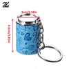 A blue metal coin tube keychain with a heart design and a silver split ring.