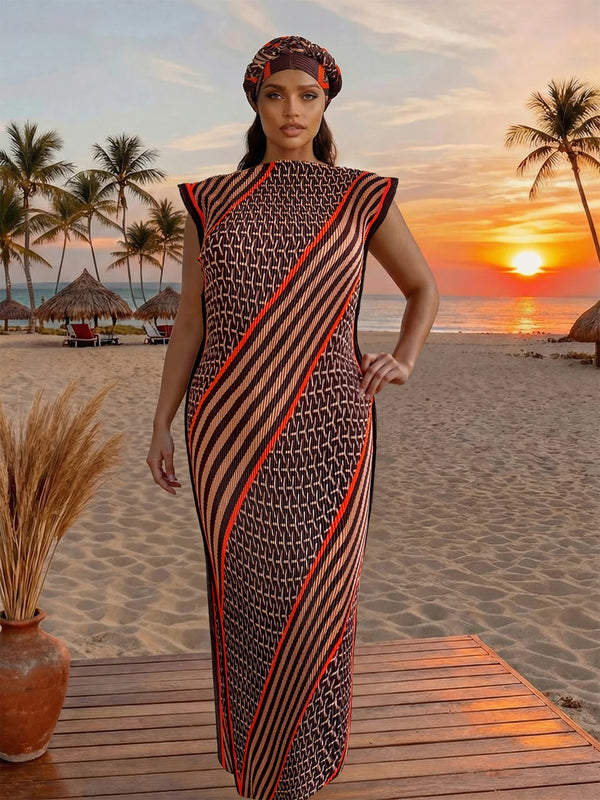 A model wearing a black and orange patterned dress standing on a wooden deck with a sunset beach background.