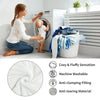 A woman is using a washing machine to clean a white plush throw blanket, demonstrating its cozy and anti-clumping features.