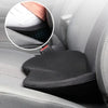 A close-up view of a black memory foam car seat cushion with lumbar support installed in a gray car seat.