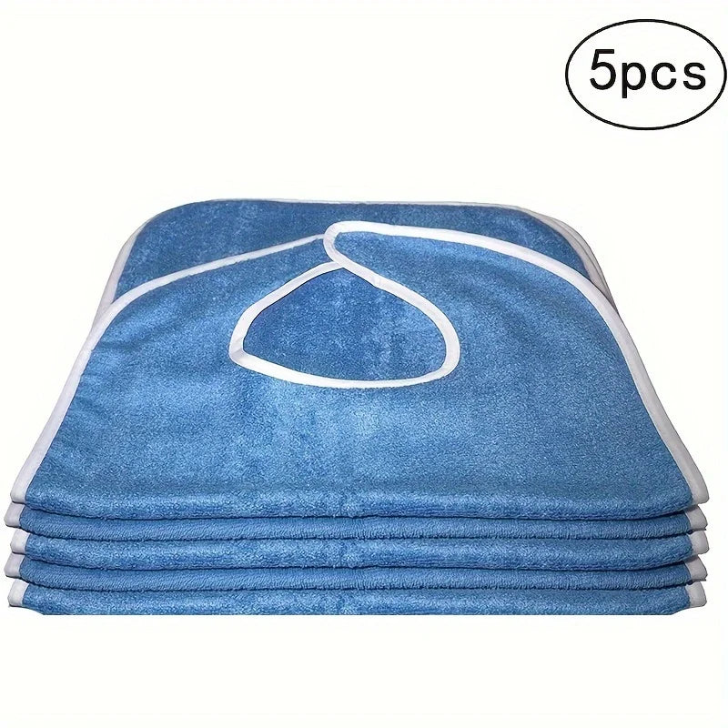 A stack of five blue flannel adult bibs with white trim for elderly and disabled care.