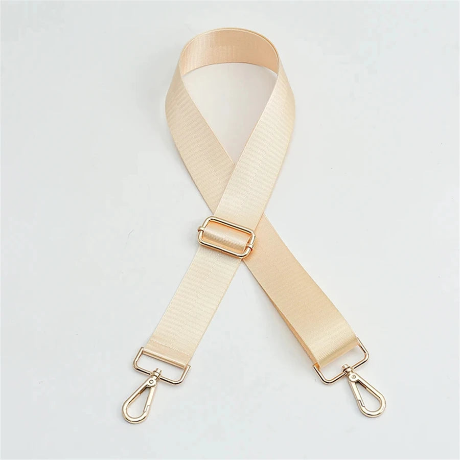 A beige nylon bag strap with a gold buckle shown diagonally.
