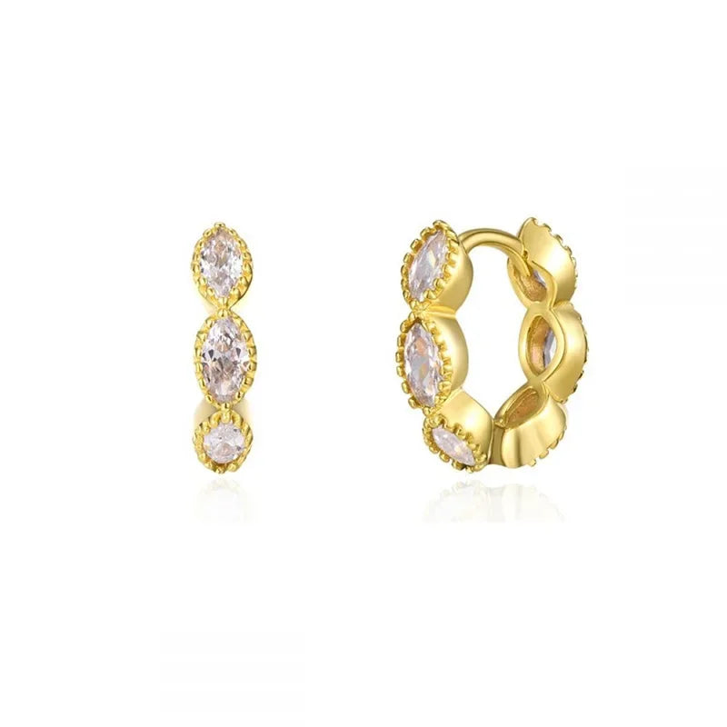 Pendientes de aro dorados con pequeñas piedras de circonita clara.