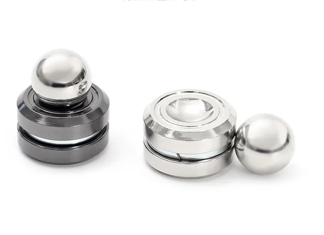 A silver metal desk spinner with a smooth ball top and base, used for stress relief.