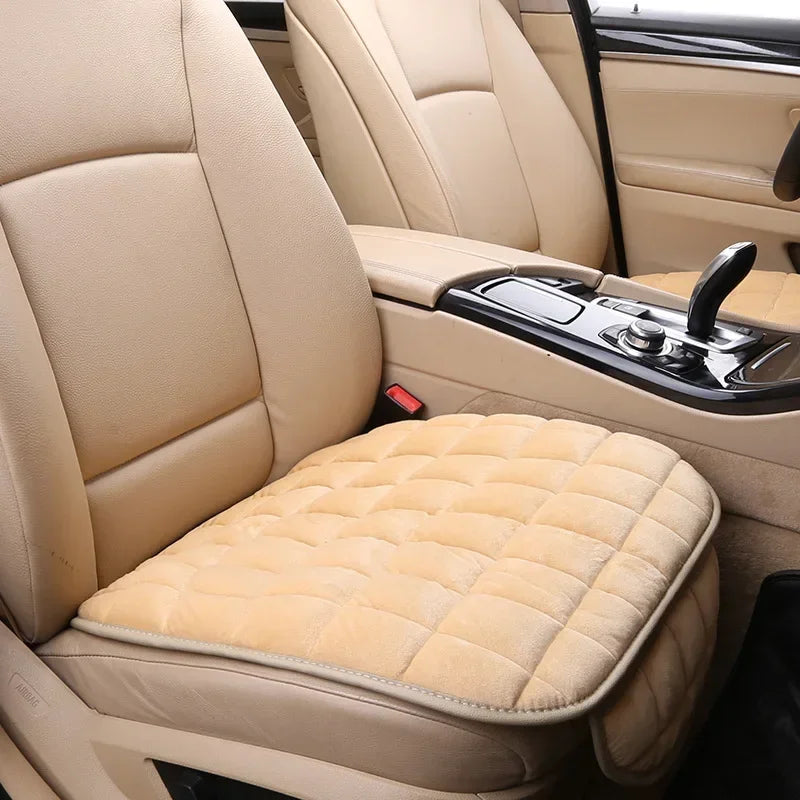 Close-up view of a beige plush car seat cover protector installed on the front seat of a vehicle.