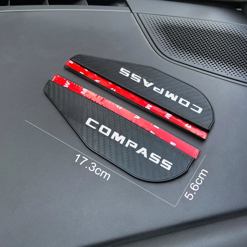 Black Compass rain guard visor with red accents shown on a dark vehicle surface.