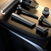 A collection of black and bronze cordless vacuum attachments resting on a dark surface.