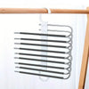 A rack of nine black stainless steel pants hangers hanging from a wooden bar.