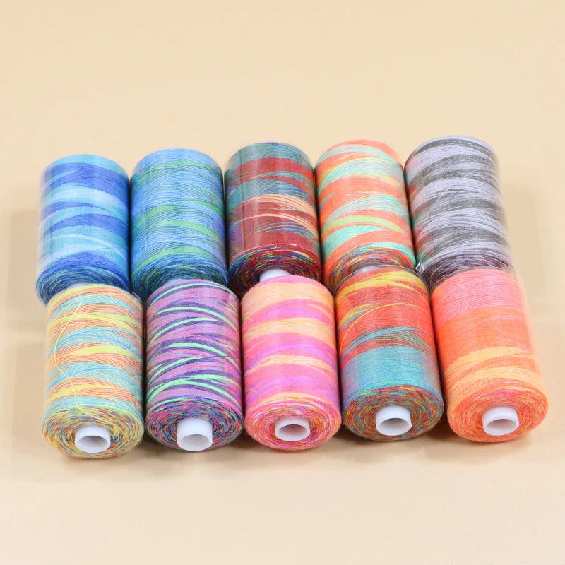 A collection of ten spools of rainbow colored polyester thread in various shades and patterns.