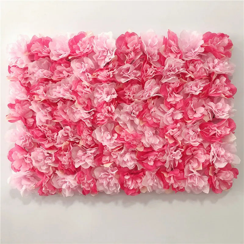 A dense wall panel made of pink silk rose flowers for weddings and events.