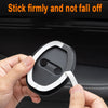 A hand is gripping a white and black silicone door lock protector, demonstrating that it sticks firmly.