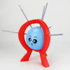 A red game piece featuring a blue balloon and several thin sticks, used for a family strategy game.