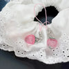 Pink strawberry resin phone charm keychain attached to white lace fabric