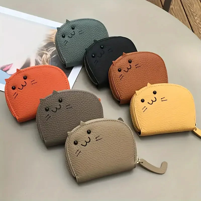 A collection of ten cartoon cat-shaped PU leather card wallets in various colors including orange, olive green, black, and ye