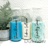 Three glass bottles filled with blue stain remover, white fabric softener, and clear laundry soap.