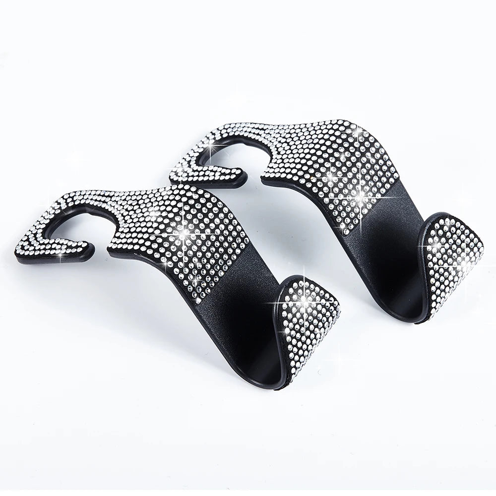 A pair of black car seat storage hooks with crystal diamond accents.