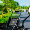 A black phone mount is attached to a motorcycle handlebar, displaying a smartphone with a navigation app.