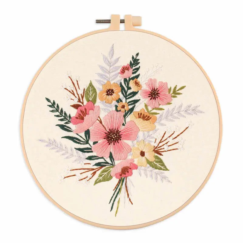 A circular embroidery hoop featuring a floral design with pink, yellow, and green foliage.
