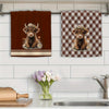 Two Highland cow plaid kitchen towels featuring a brown calf surrounded by flowers.