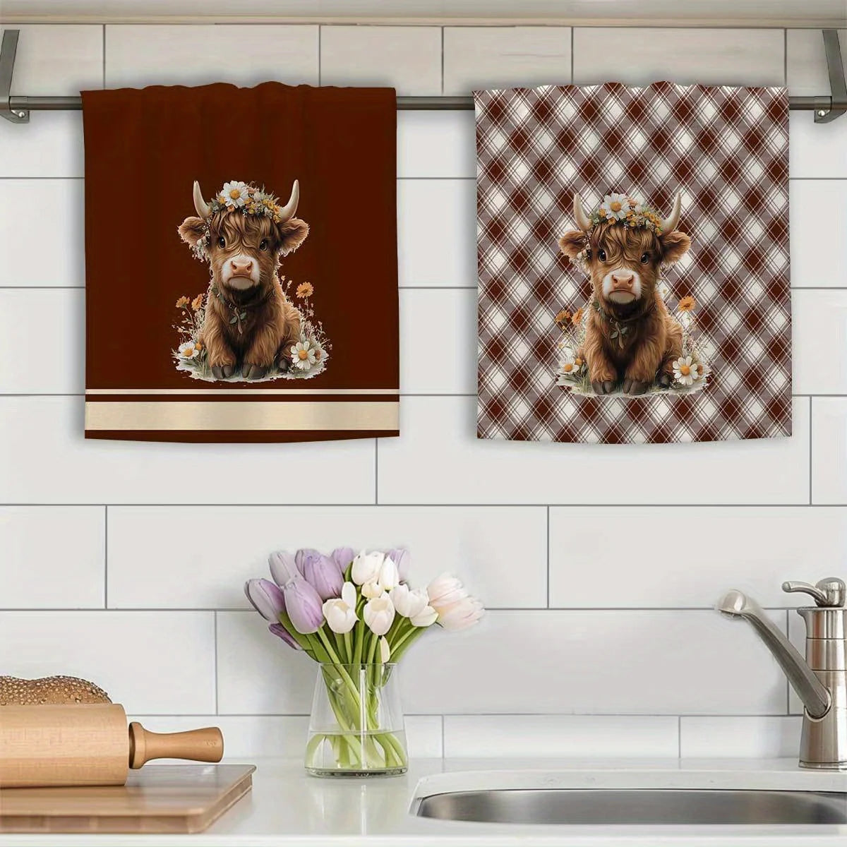 Two Highland cow plaid kitchen towels featuring a brown calf surrounded by flowers.
