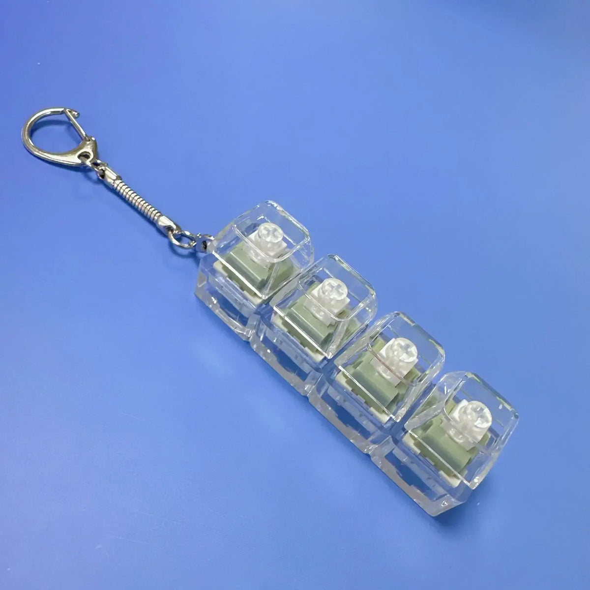 A clear acrylic LED light-up keyboard keychain fidget toy attached to a silver keyring.
