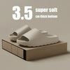 A pair of beige cloud-soled EVA slides resting on a wooden block.