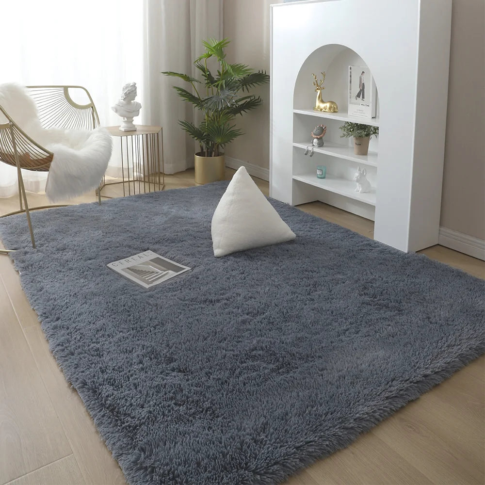 A fluffy gray rug with white accent pillows placed in a bright living room setting.