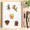 A set of five stickers featuring dogs, including a golden retriever, a hound, and other breeds, placed on lined notebook pape