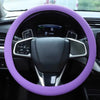 A purple silicone steering wheel cover on a car's steering wheel.