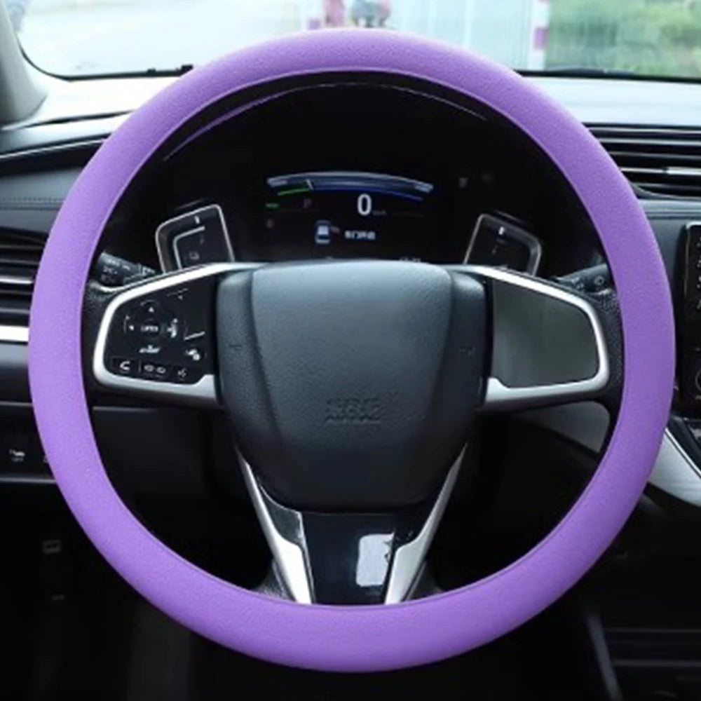 A purple silicone steering wheel cover on a car's steering wheel.