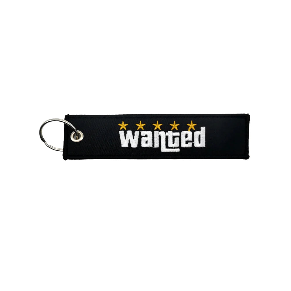 Black nylon keychain with embroidered yellow stars and the word wanted
