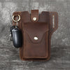 A brown genuine leather waist bag with a flap and multiple pockets, featuring a black pen and keys.