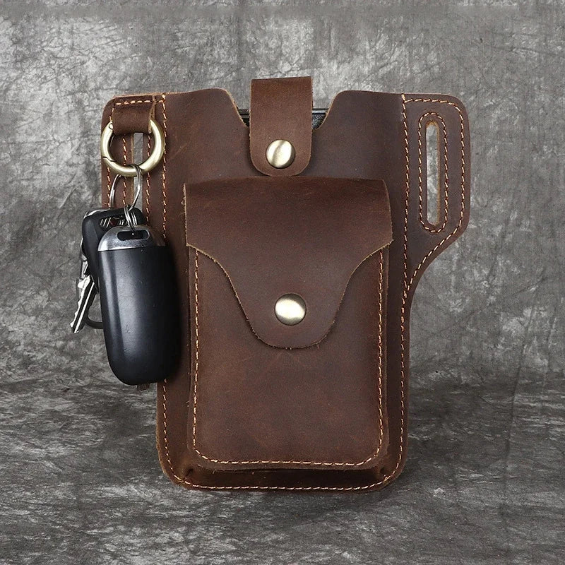 A brown genuine leather waist bag with a flap and multiple pockets, featuring a black pen and keys.