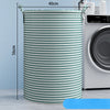 A tall, cylindrical foldable laundry basket with green and white stripes is shown next to a washing machine.