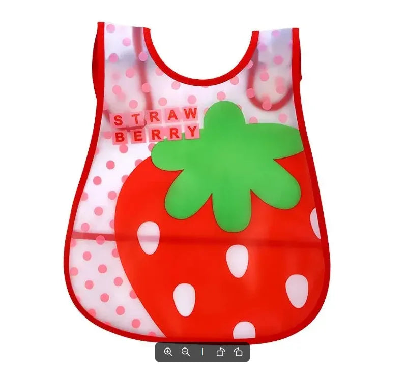 A wipeable baby bib shaped like a strawberry with a green leafy top and white polka dots.