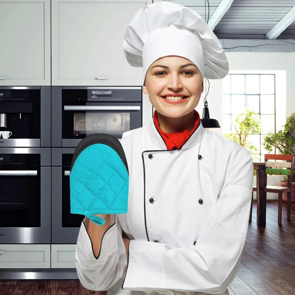 A smiling woman wearing a white chef coat and hat holding a blue silicone oven mitt.