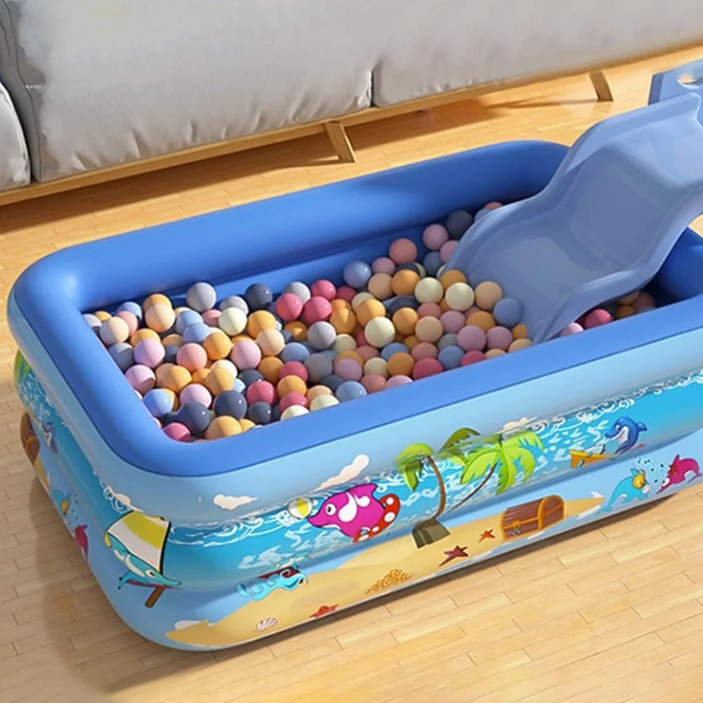 Grande piscine gonflable bleue pour la famille remplie de balles en plastique colorées et d'une patinoire bleue.