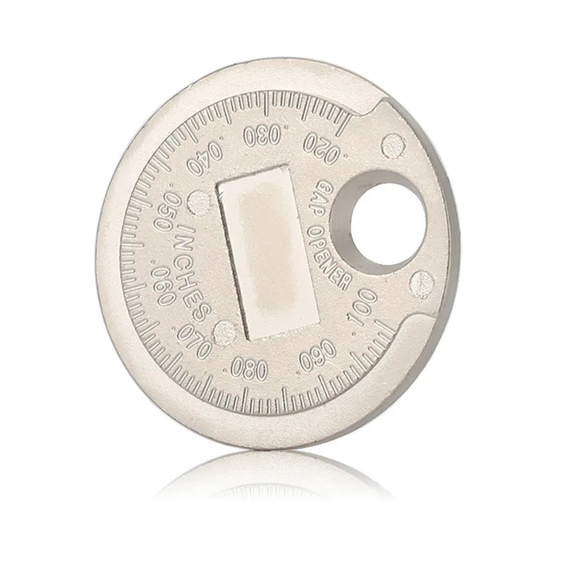 A circular metal gauge with markings for measuring spark plug gap, showing a gap between 0.6 and 2.4 mm.