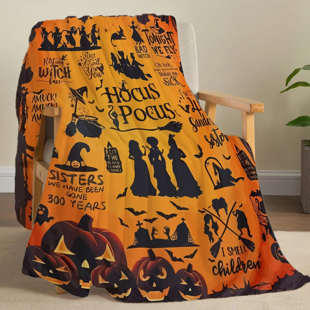 An orange Halloween themed flannel throw blanket featuring carved pumpkins and witches on a wooden chair.