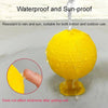 A yellow sticky fruit fly trap ball being dropped into water, demonstrating waterproof and sun-proof properties.
