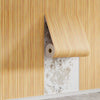 Vertical striped wood grain peel-and-stick wallpaper installed on a wall.