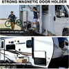 A man holds an entry door open on a white RV, demonstrating a strong magnetic door holder.