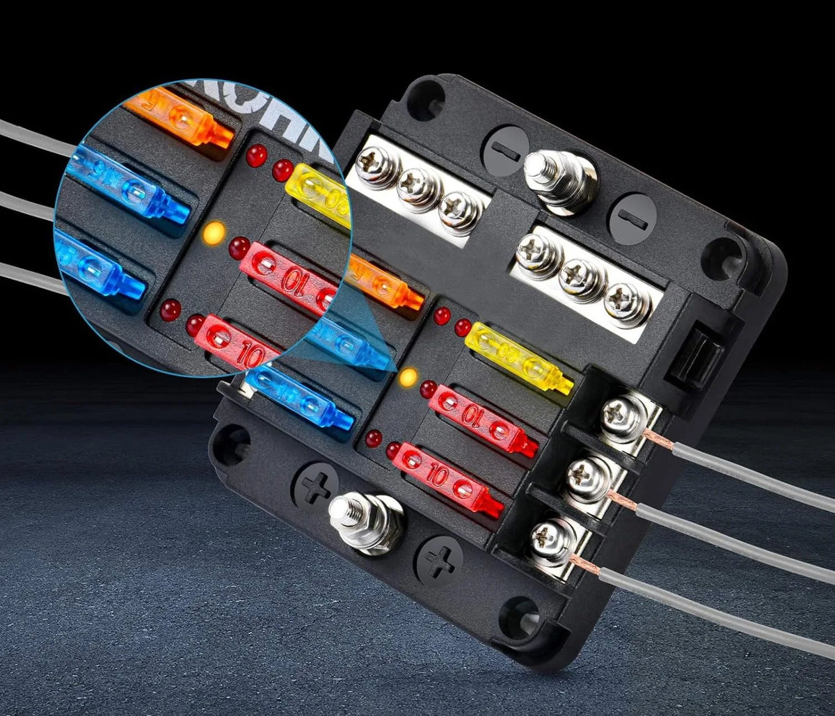 Black storage box containing an assortment of blade fuses with various colored plastic bodies and metal terminals.