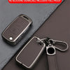 A dark metal key case cover for a car key, shown with a leather strap and a metal keyring.