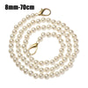 A strand of small, round, off-white pearls on a gold-toned chain.