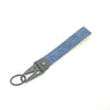 A gray keychain featuring a blue and white Kanagawa surf design on a wooden-look strap.